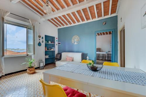 Una sala de estar con una mesa y sillas amarillas. en Casa Le 3 B con vista mare, en Portoferraio