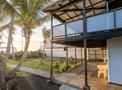 a house with a balcony with palm trees at Caribbean Queen - Apartamento con vista al Jardin #2 in San Andrés