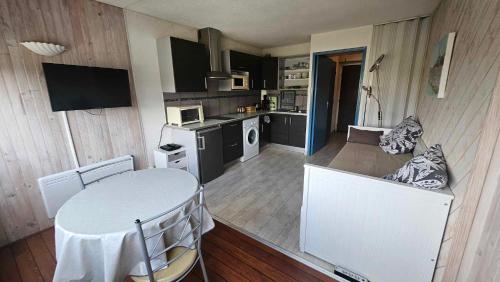 una cucina con un tavolo bianco e un tavolo e sedie di Studio plage du Grazel a Gruissan