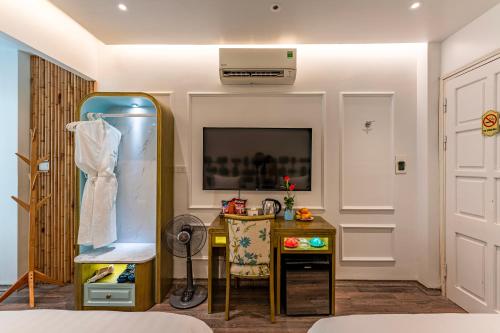 a bedroom with a dressing table and a tv at Mai Hotel in Hanoi