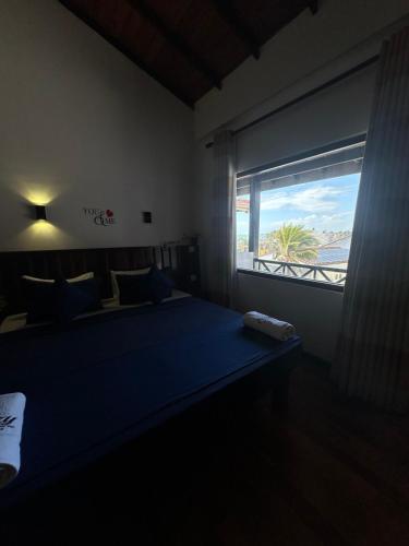 a bedroom with a bed and a window with a view at Cozy Sea view Inn in Hikkaduwa
