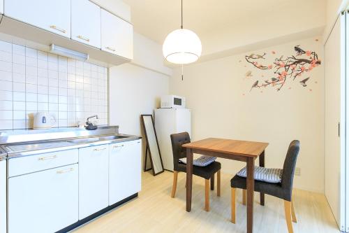 a kitchen with a table and chairs and a refrigerator at NT Building in Nagoya