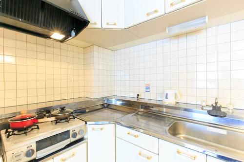 a kitchen with a stove and a sink at NT Building in Nagoya