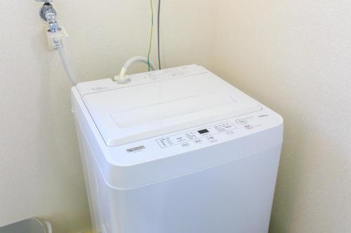 a white washing machine with a cord on top of it at NT Building in Nagoya