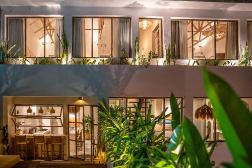 a house with plants in front of it at Maison Matahari Apartment Canggu in Kuta