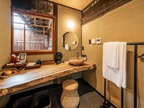a bathroom with a sink and a mirror at NIPPONIA MIYAMA TSURUGAOKA Mountain Village in Ōno