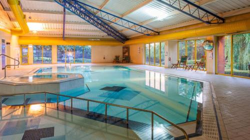 a large indoor swimming pool in a building at Holiday Inn Runcorn M56 Junction 12 by IHG in Runcorn
