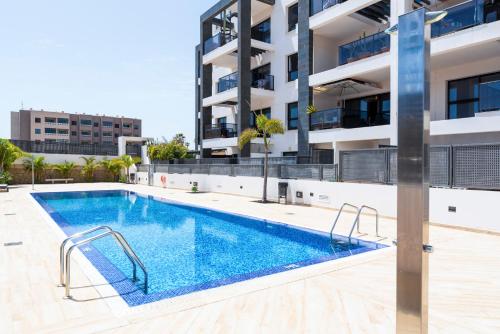 a swimming pool in front of a apartment building at MEDANO4YOU Westside Penthouse in El Médano