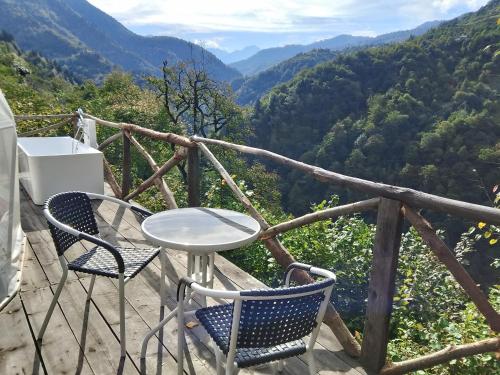 a table and chairs on a balcony with a view of mountains at Glamping Machakhela 2 in Ch'ik'unet'i