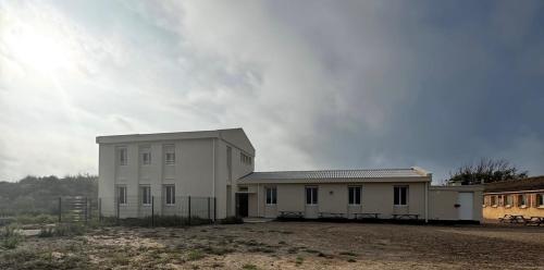 un bâtiment blanc au milieu d'un champ dans l'établissement Mer Et Soleil, à Valras-Plage