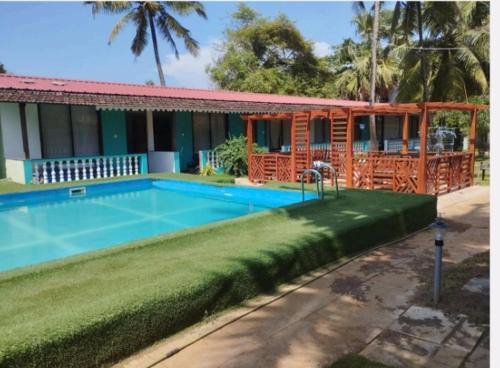a house with a swimming pool in front of it at Rock Bite Beach Resort morjim beach in Old Goa
