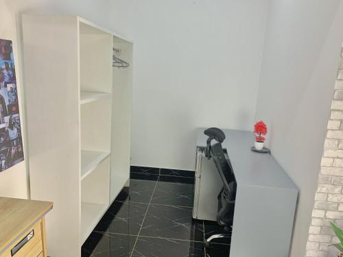 a kitchen with white cabinets and a black tile floor at Studio Le Parisien in Pointe-Noire