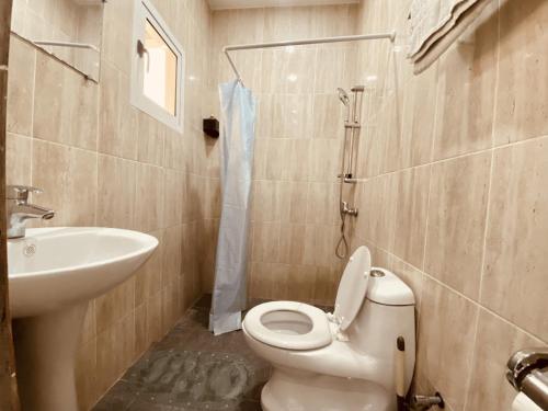 a bathroom with a toilet and a sink at Studio Le Parisien in Pointe-Noire
