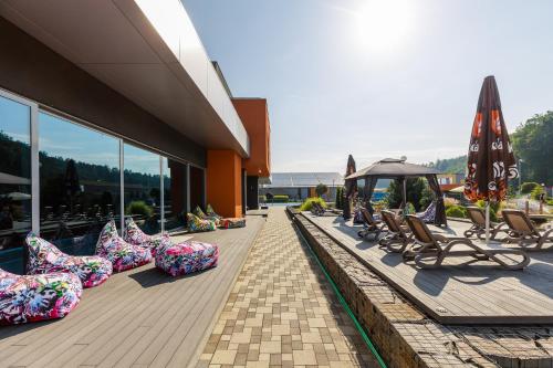 a row of lounge chairs and umbrellas on a building at Hotel TENIS in Zvolen