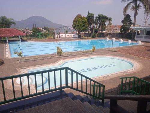 a large swimming pool in front of a resort at Villa Barbie Green Hill Cipanas Cianjur in Panyaweuyan