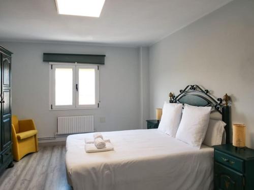 フェロルにあるApartamento Porta Novaのベッドルーム(大きな白いベッド1台、黄色い椅子付)