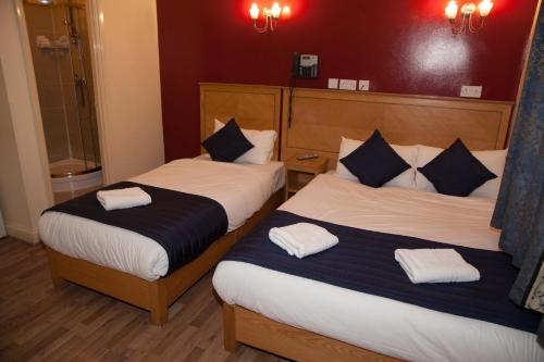 Dos camas en una habitación de hotel con toallas. en St Mark Hotel en Londres