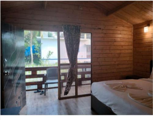 a bedroom with a bed and a window with a curtain at Rock Bite Beach Resort morjim beach in Old Goa