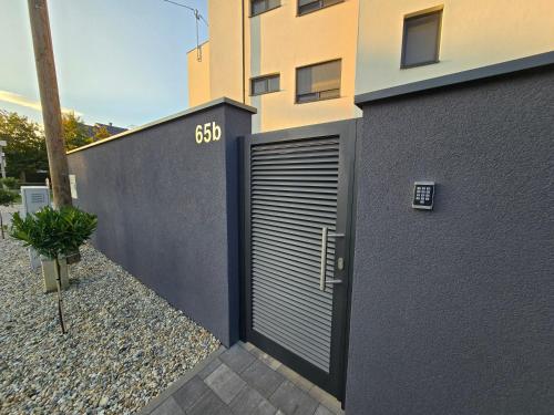 a building with a garage door on the side of it at Apartman FIŠBAH 4 self CHECK-IN, FREE PRIVATE PARKING in Osijek