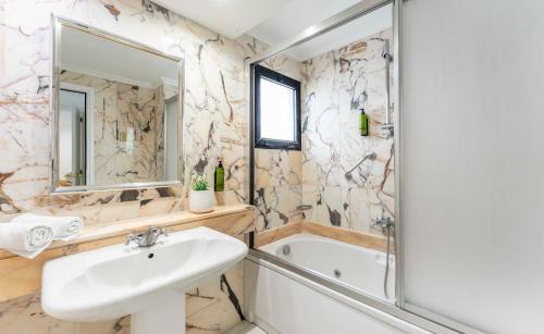 a bathroom with a sink and a tub and a mirror at Ona Hollywood Mirage in Los Cristianos
