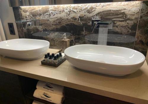 a bathroom with two white sinks on a counter at Botanique Suites AirBnB, Antwerp in Antwerp