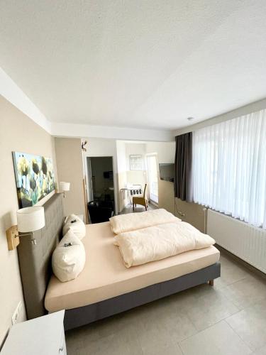 a bedroom with a large bed and a window at Gästehaus Astrids Strandmuschel in Binz