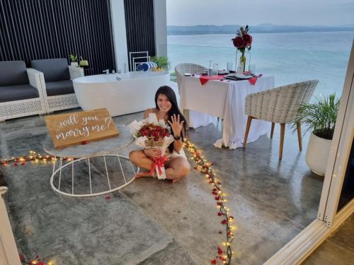 a woman sitting on the floor with a bouquet of flowers at Epic Suites Bohol ADULTS ONLY in Dauis