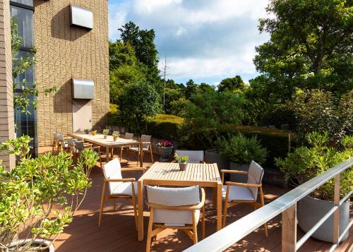 a patio with tables and chairs on a balcony at Hotel Grand Bach Atami Crescendo in Atami
