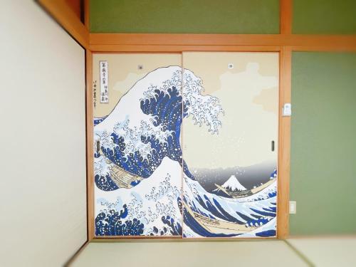 a picture of the wave in a wooden frame at 南町駅徒歩2分 松山城や道後温泉へ好アクセス 一軒家貸切り和の家 11人まで 駐車場無料 in Matsuyama