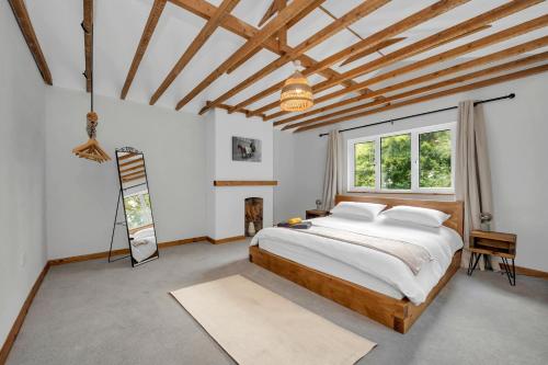 a bedroom with a bed and a large window at Stunning 2 Lodge Cottage retreat in Little Saxham