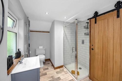 a bathroom with a shower and a sink and a toilet at Stunning 2 Lodge Cottage retreat in Little Saxham