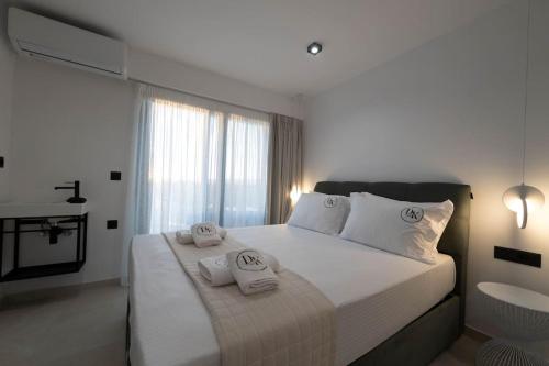 a bedroom with a large bed with towels on it at KEDL Junior Suites in Kalamata