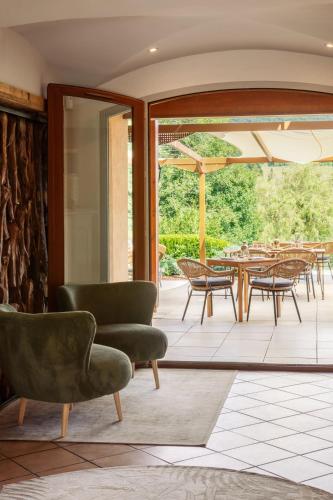 un vestíbulo con sillas y mesas y un patio en L'Arborescence, en Cruseilles