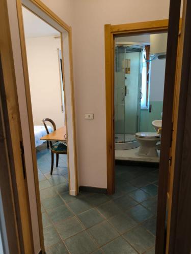a bathroom with a toilet and a glass doorway at L'Ambra in Alghero