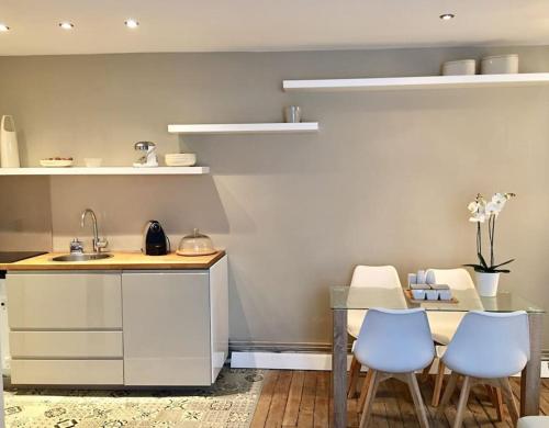 - une cuisine avec un évier, une table et des chaises dans l'établissement Confort Relaxant Gare du Nord Barbès, à Paris