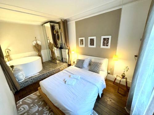 une chambre avec un grand lit et une baignoire dans l'établissement Confort Relaxant Gare du Nord Barbès, à Paris