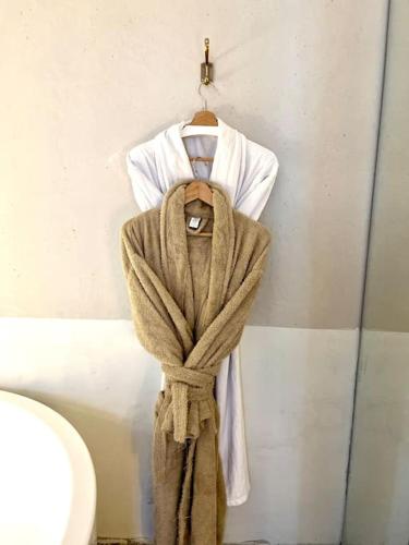 un peignoir accroché sur un mur à côté de toilettes dans l'établissement Confort Relaxant Gare du Nord Barbès, à Paris