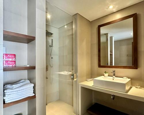 ein Badezimmer mit Waschbecken, Spiegel und Dusche in der Unterkunft COZY Studio in A La Carte Da Nang in Đà Nẵng