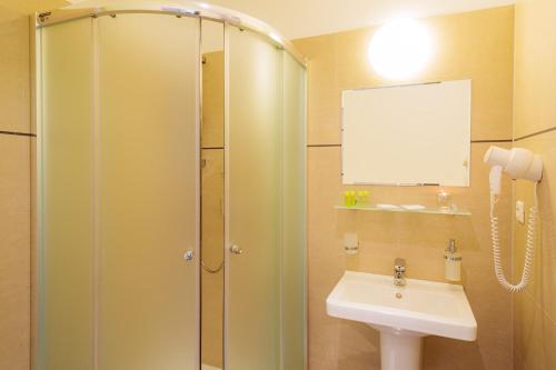 a bathroom with a shower and a sink at Hotel TENIS in Zvolen