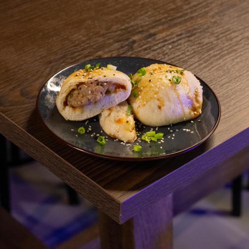 a plate of food on a wooden table at JOST Hostel Lille Centre in Lille
