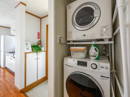 a washing machine in a kitchen with a microwave at SEA EIRENE Hillstop Onnason in Inbu