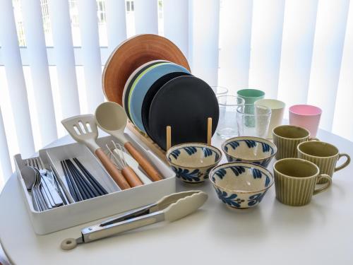 a table with plates and utensils and cups at SEA EIRENE Hillstop Onnason in Inbu