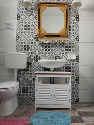 a bathroom with a sink and a mirror on a wall at City Center First Floor Apartment in Kos