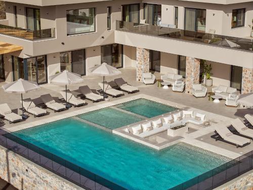 an overhead view of a swimming pool with chairs and umbrellas at Hue Villa, Stunning Southern Beaches, By ThinkVilla in Asómatoi