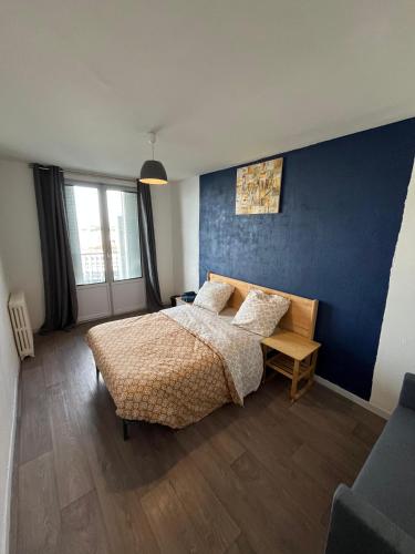 une chambre avec un lit et un mur bleu dans l'établissement Chambre chez Bryan, à Toulouse