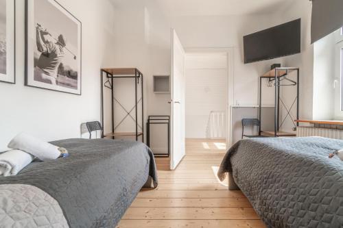 a bedroom with two beds and a flat screen tv at WORKER'S HOME F7 - Haus mit 4 Schlafzimmern für 8 Personen in Wesel