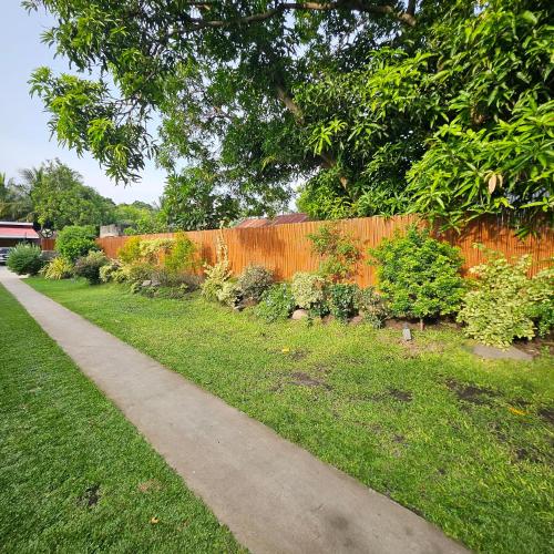 a garden with an orange fence and a sidewalk at Casa Celine Dumaguete in Dumaguete
