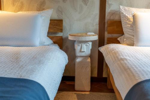 a bedroom with two twin beds and a nightstand between them at Suflora in Mengara