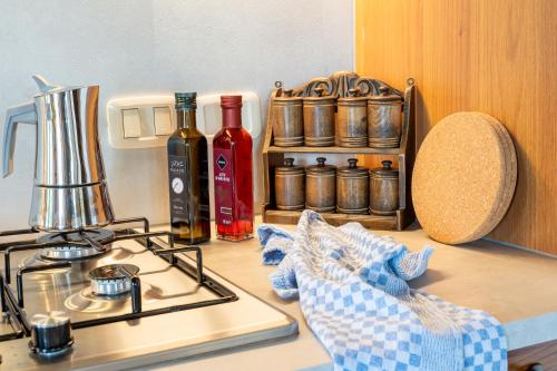 a kitchen counter with a stove and bottles of wine at Suflora in Mengara