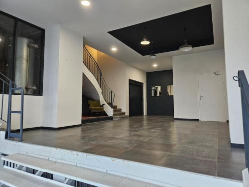 une grande pièce vide avec un escalier dans un bâtiment dans l'établissement DK Lodges Netflix Wifi Proche centre ville, à Pau